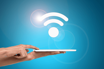 a hand holding a tablet with a wifi symbol above it